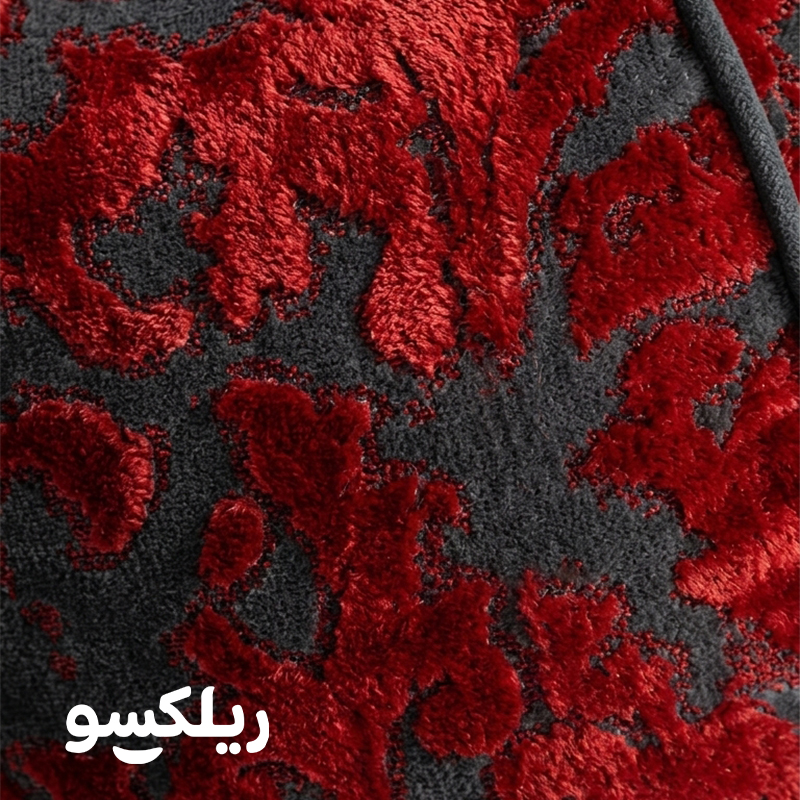 نمای نزدیک پارچه مخمل برجسته مبل شنی اسلیمی؛ بافت طرح‌دار قرمز روی زمینه طوسی بین بگ لاکچری